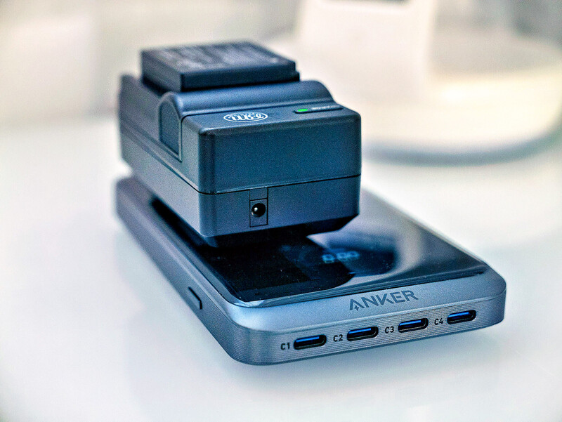 Anker portable charging dock with blue smartphone mounted on top, displaying multiple USB-C ports.
